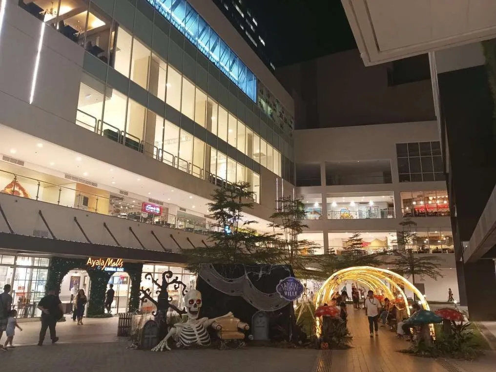 Mid section of Ayala Malls Central Bloc that's open air with benches decorated with grass and plants to chill. Additional with Halloween decoration because it's the season.