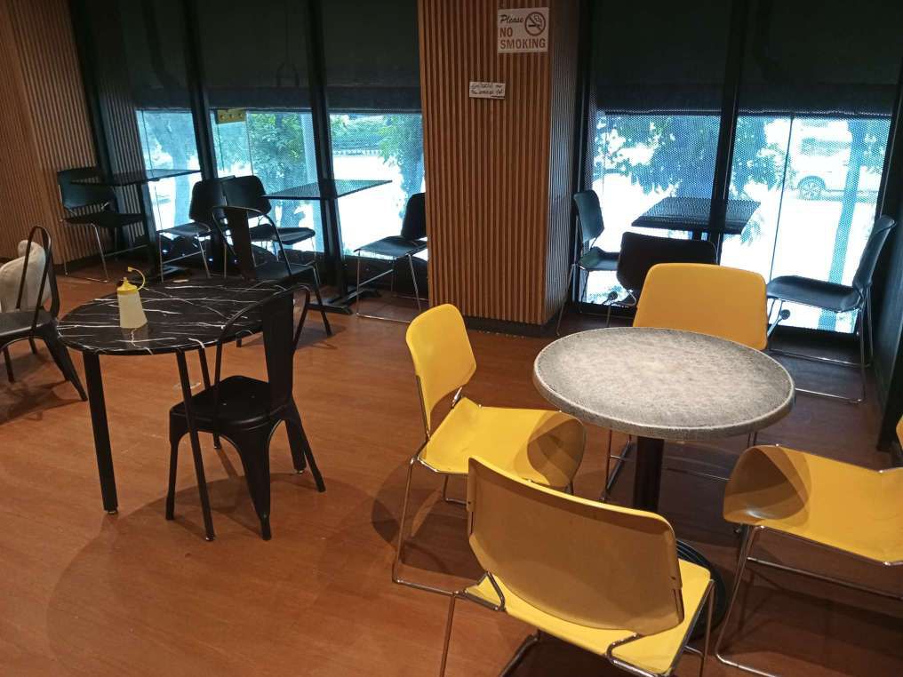 Quikstop 2nd floor dining room with yellow and black tables. This floor has wooden interior finish.